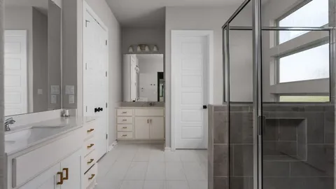a spacious bathroom with a double vanity sink a mirror and a bathtub