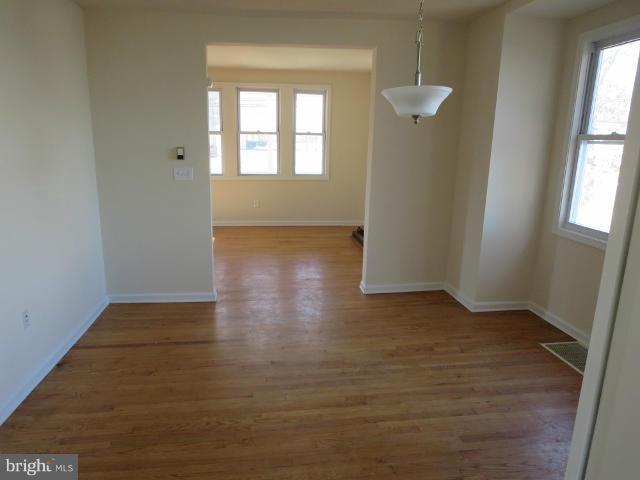 7604 North Point Road Baltimore, MD 21219 - Photo 3 of 13 an empty room with wooden floor and windows