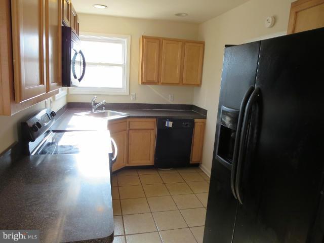 7604 North Point Road Baltimore, MD 21219 - Photo 5 of 13 a kitchen with stainless steel appliances a refrigerator and a sink