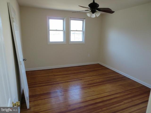 7604 North Point Road Baltimore, MD 21219 - Photo 9 of 13 wooden floor in an empty room with a window