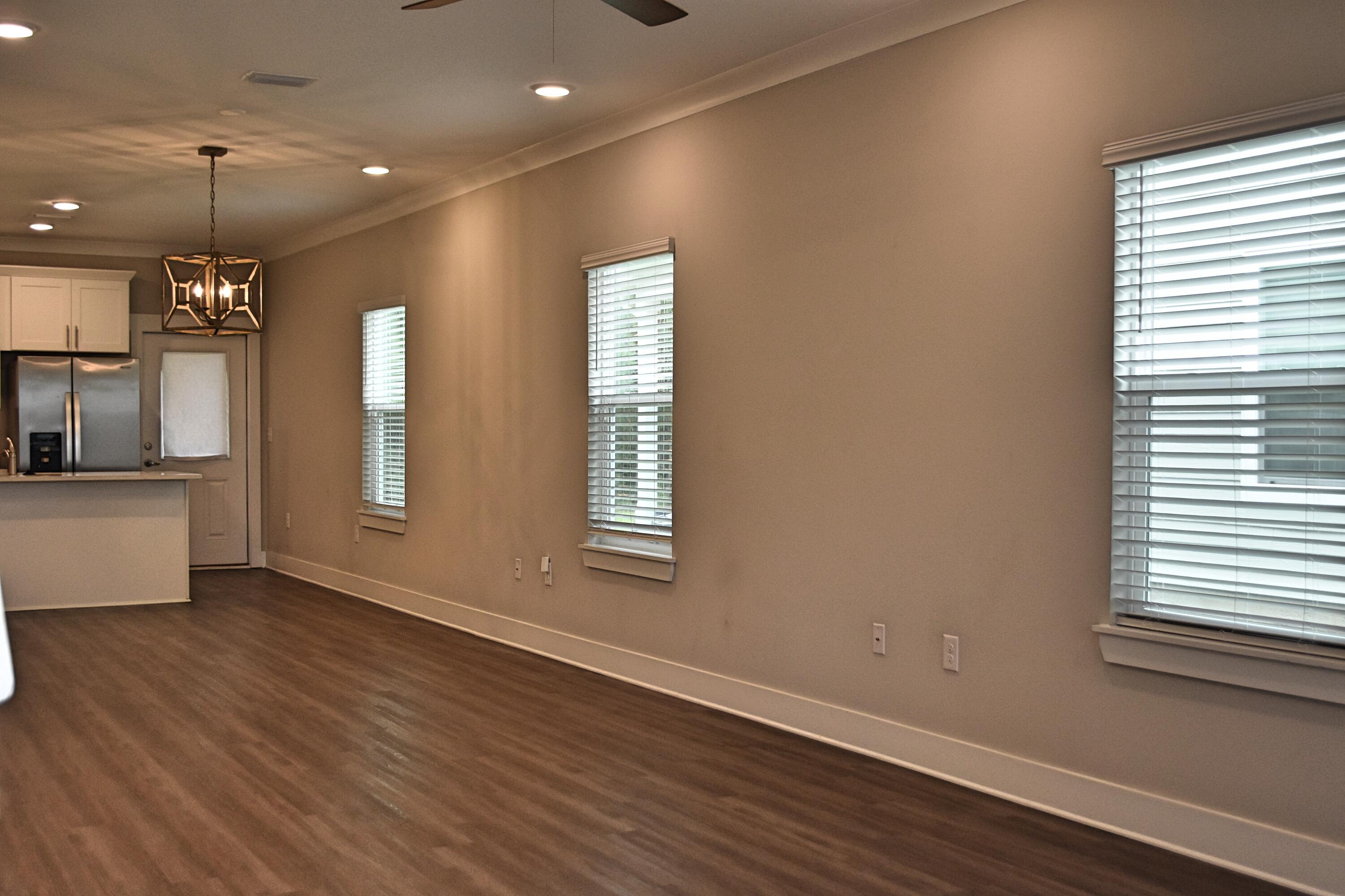 242 North Sand Palm Road Freeport, FL 32439 - Photo 5 of 34 an empty room with wooden floor and windows