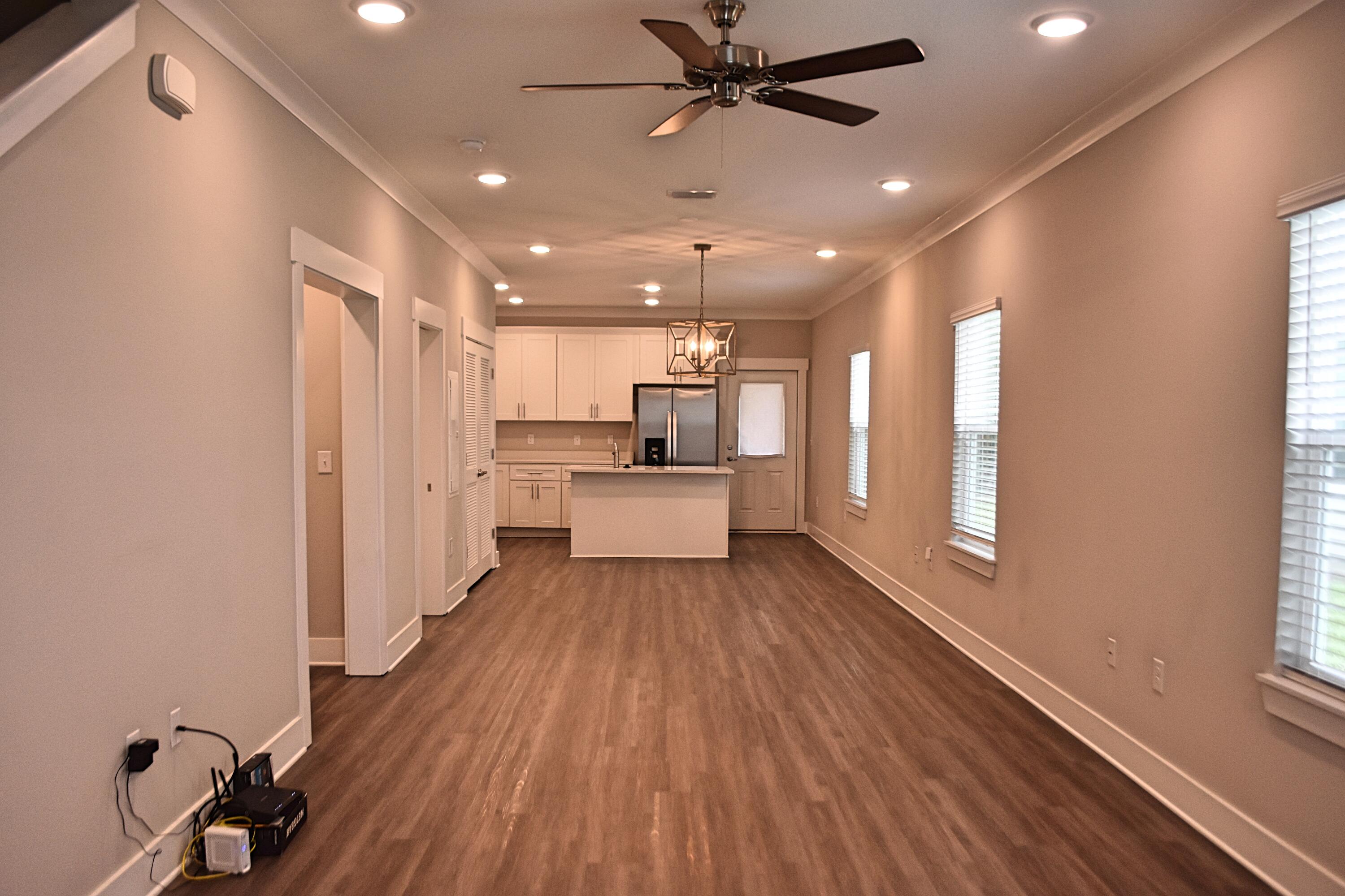 242 North Sand Palm Road Freeport, FL 32439 - Photo 6 of 34 a open kitchen with white cabinets and wooden floor