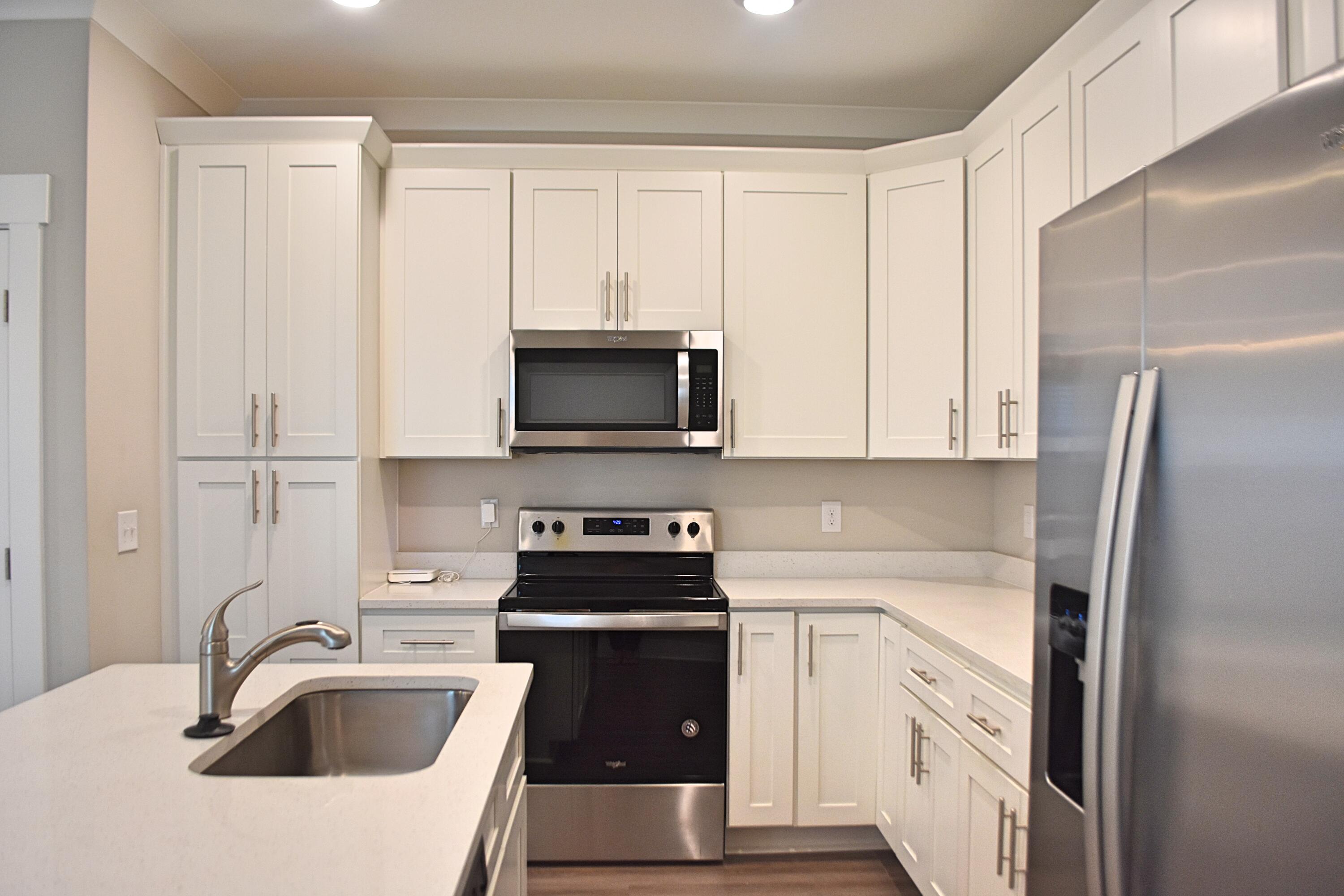 242 North Sand Palm Road Freeport, FL 32439 - Photo 10 of 34 a kitchen with white cabinets and stainless steel appliances