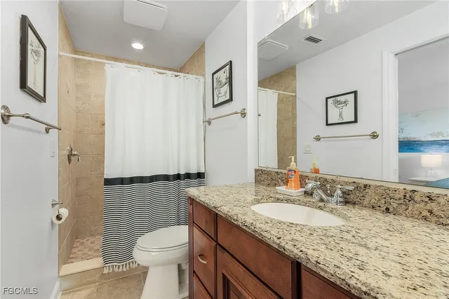 a bathroom with a granite countertop sink toilet and shower