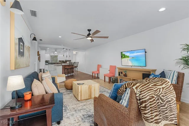 a living room with furniture kitchen view and a chandelier