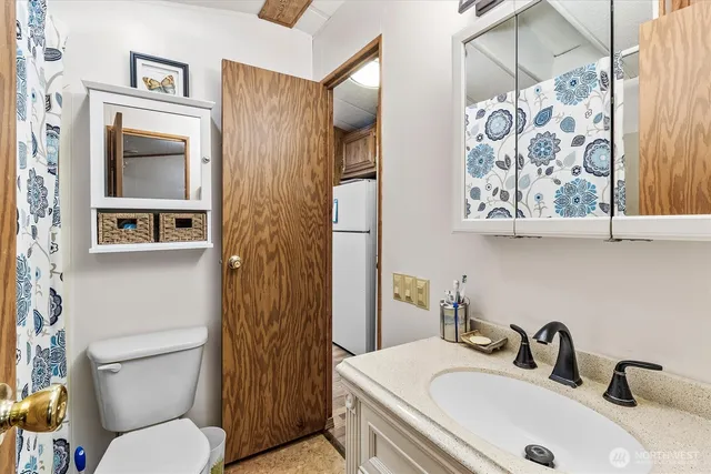 a bathroom with a toilet sink and shower curtain