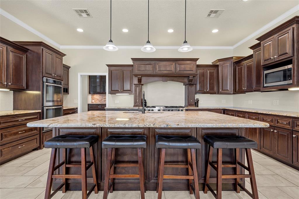 2743 Tokio Road West, TX 76691 - Photo 13 of 40 a kitchen with stainless steel appliances granite countertop a table chairs sink and wooden cabinets