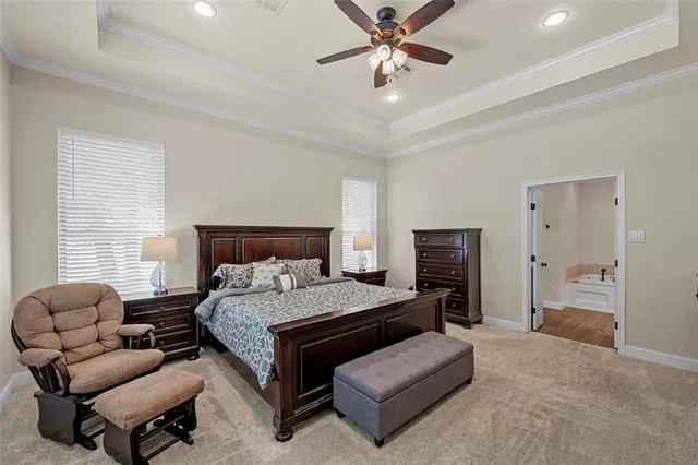 a bedroom with a bed couches and a flat screen tv