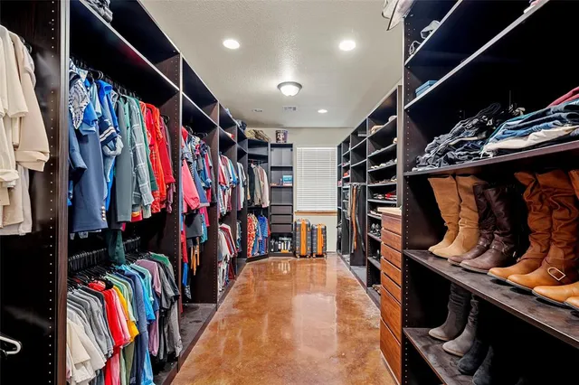 a view of walk in closet with clothes and shoes