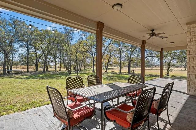 a view of a patio with a table chairs and a backyard