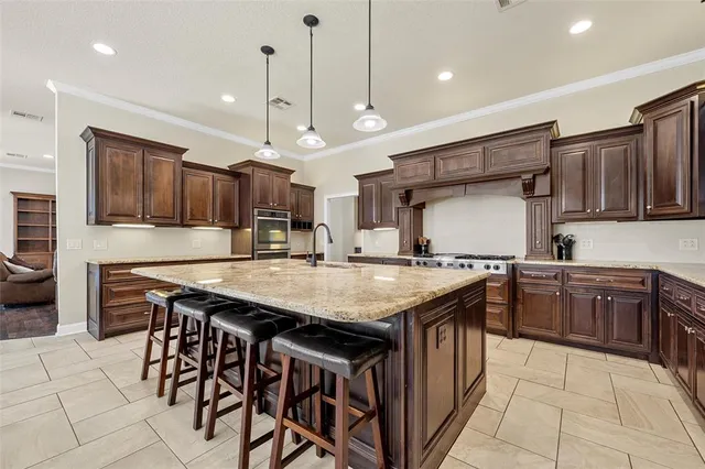 a kitchen with stainless steel appliances granite countertop a stove a sink and a refrigerator
