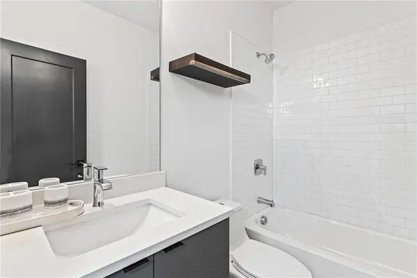 a bathroom with a bathtub shower sink and a toilet