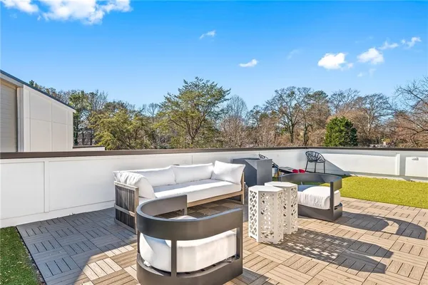 a roof deck with couches and wooden floor