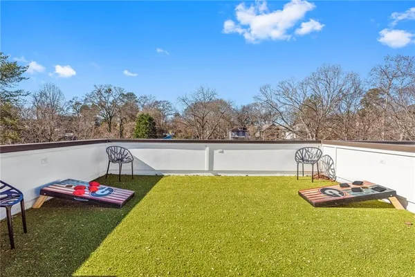 a view of swimming pool with seating space and trees in the background