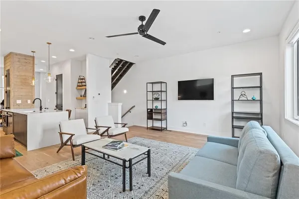 a living room with furniture a flat screen tv and a table
