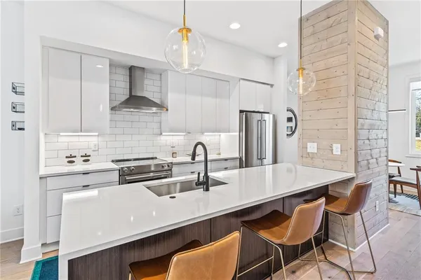 a kitchen with stainless steel appliances a sink a stove a refrigerator and cabinets