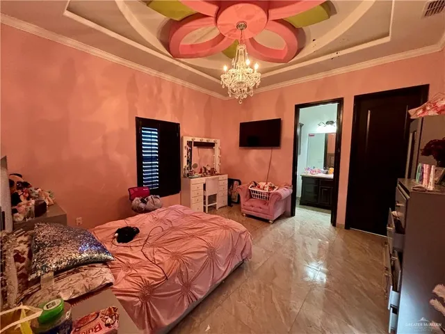a bedroom with bed and a chandelier