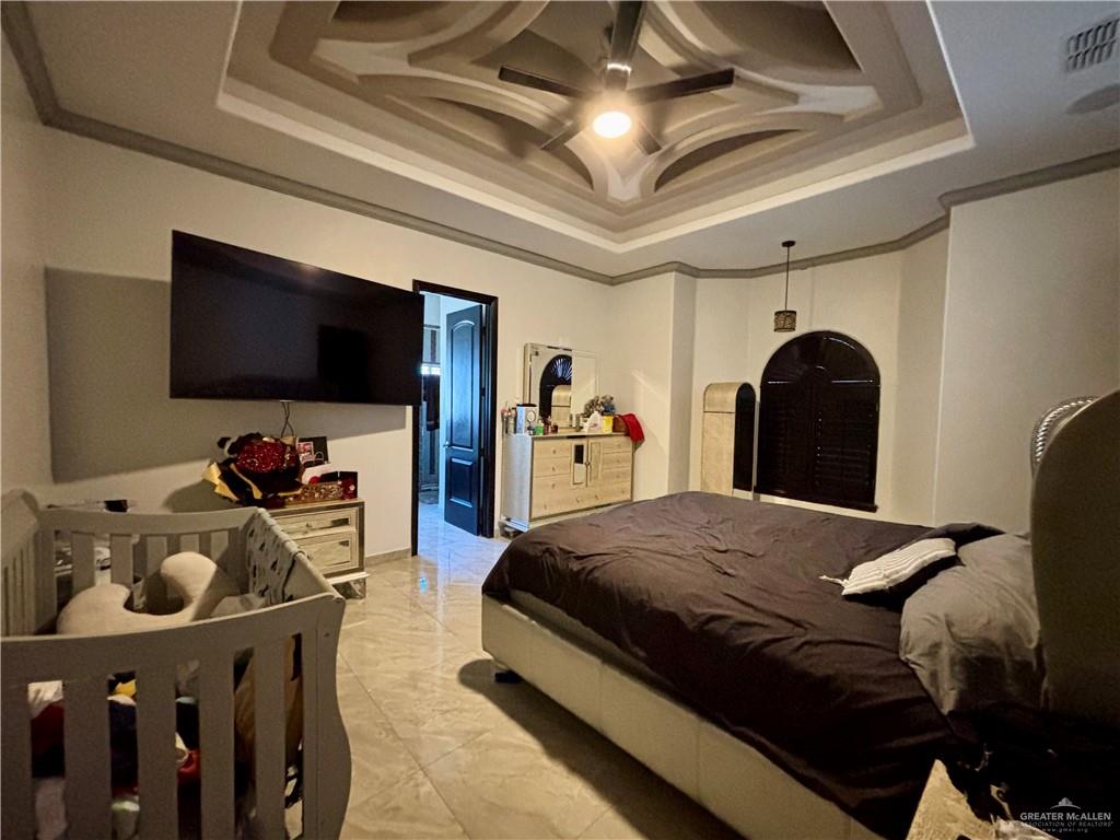 404 South Resplandor Street Mission, TX 78572 - Photo 9 of 19 a bedroom with a bed and a flat tv screen on dresser