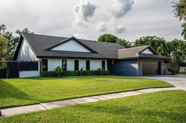 a front view of a house with a garden and yard