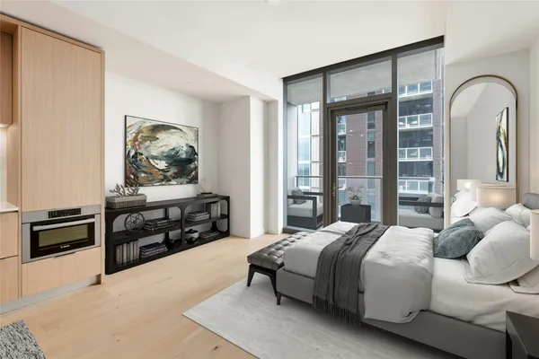 a bedroom with a bed and a dresser next to a window