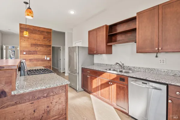 a kitchen with a stove and a wooden floor