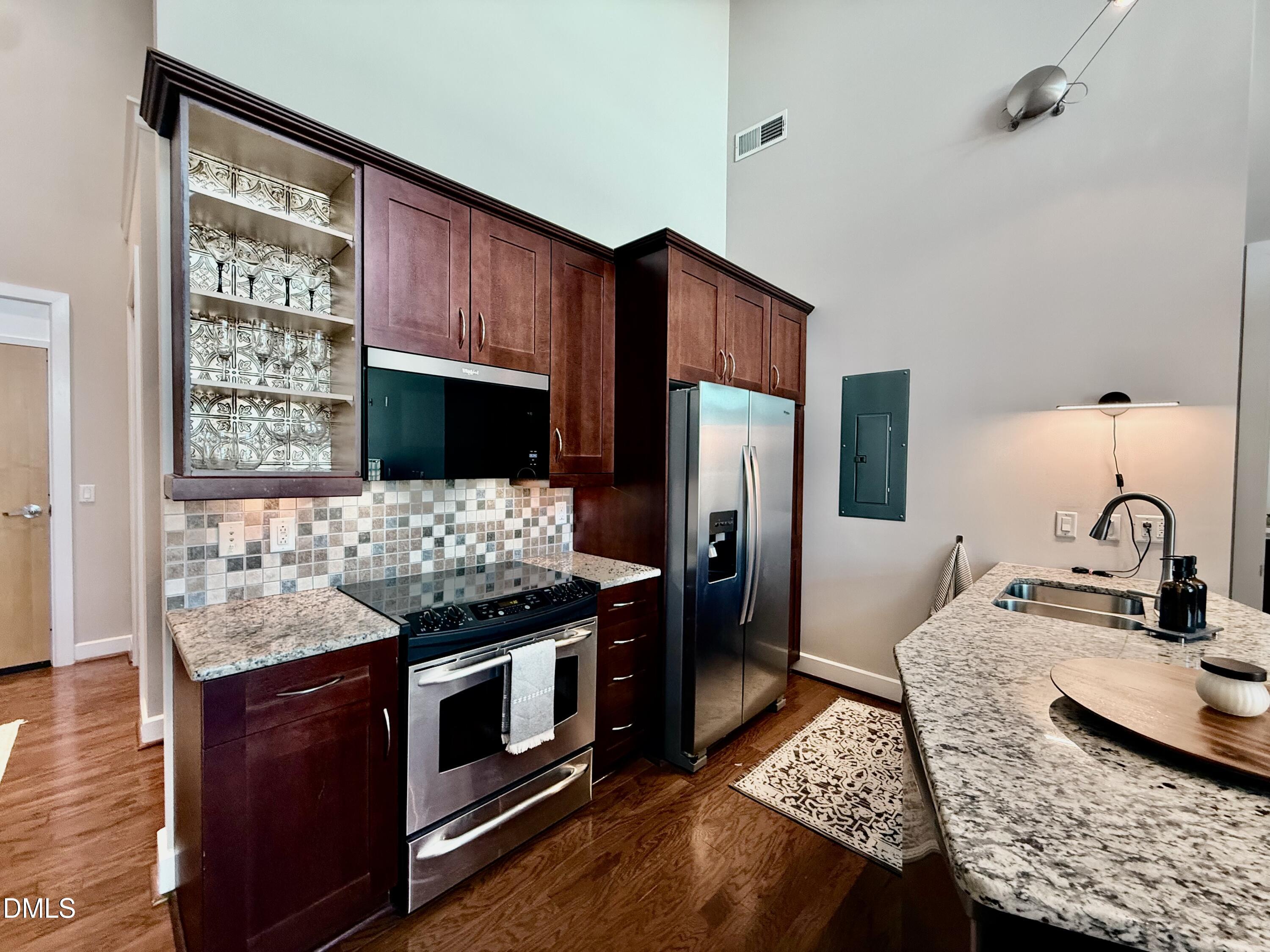 2608 Erwin Road, Unit 421 Durham, NC 27705 - Photo 11 of 45 a kitchen with stainless steel appliances kitchen island granite countertop a stove refrigerator and microwave