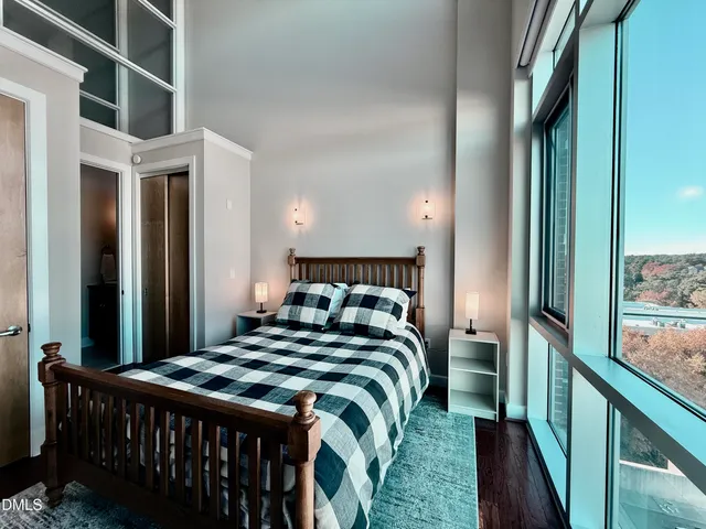 a bedroom with a bed and large window