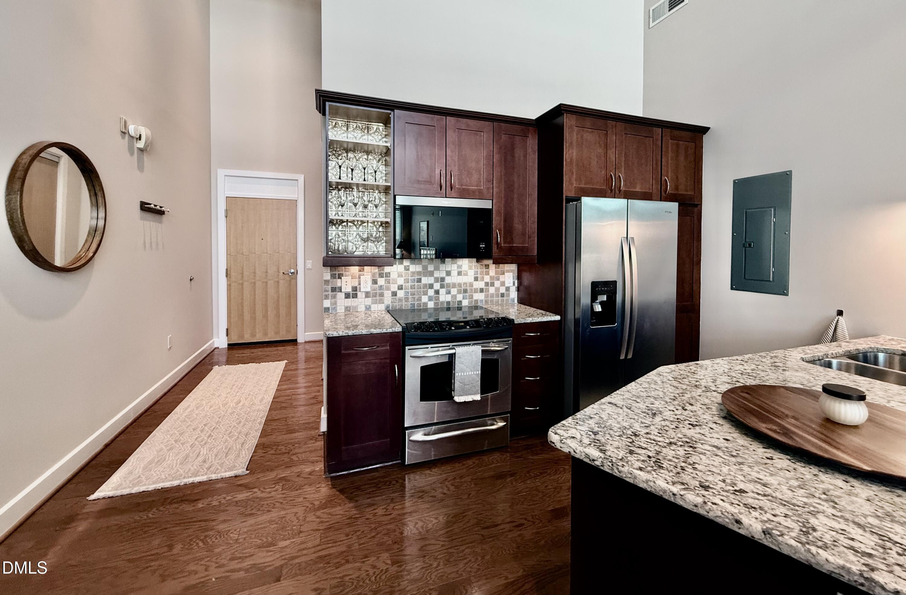 2608 Erwin Road, Unit 421 Durham, NC 27705 - Photo 7 of 45 a kitchen with kitchen island granite countertop wooden cabinets and stainless steel appliances