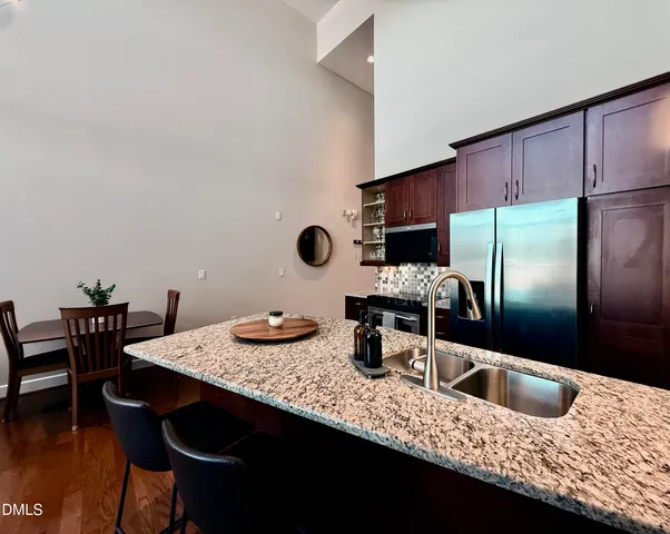 a kitchen with stainless steel appliances kitchen island granite countertop a stove refrigerator and microwave