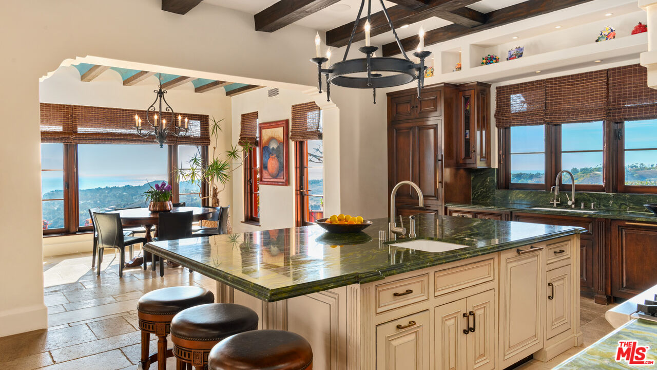 6093 Murphy Way Malibu, CA 90265 - Photo 16 of 52 a kitchen with stainless steel appliances granite countertop a sink and wooden cabinets