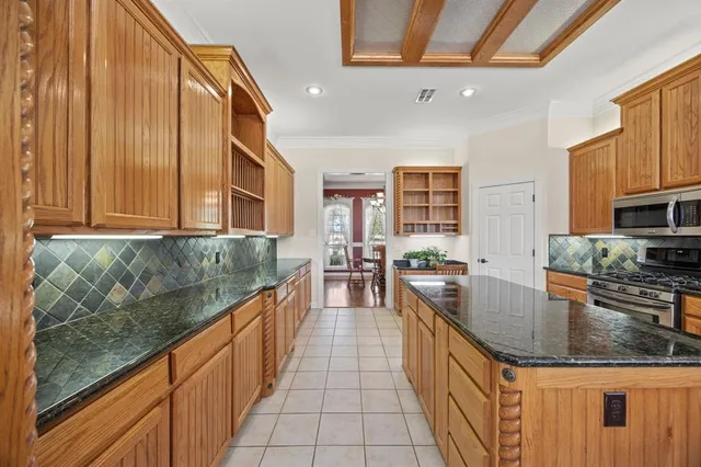 a kitchen with stainless steel appliances granite countertop a stove a sink and a microwave