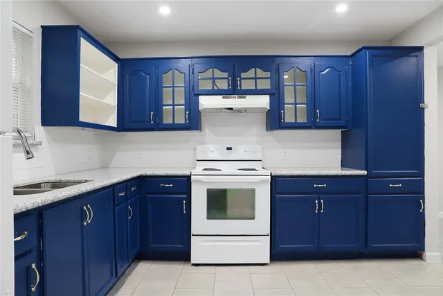 a kitchen with a stove sink and cabinets