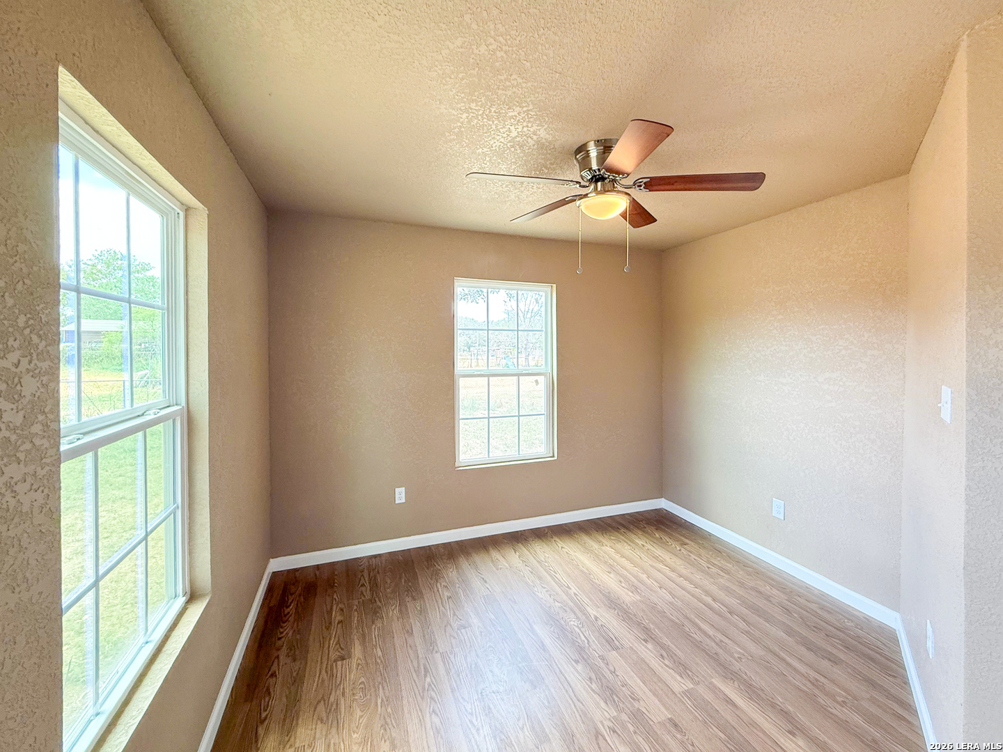 303 Davis Avenue Devine, TX 78016 - Photo 8 of 16 a view of empty room with wooden floor and fan