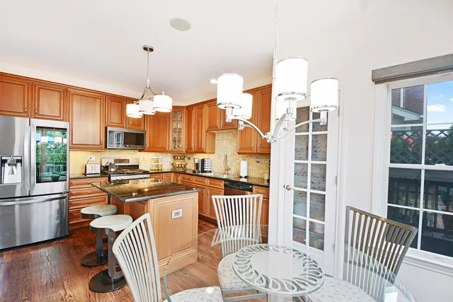 a kitchen with stainless steel appliances granite countertop a stove a sink a dining table and chairs