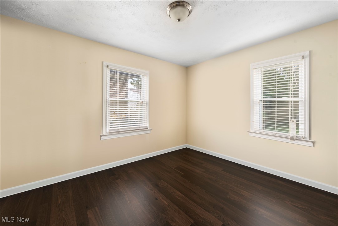 187 Everhard Road Southwest North Canton, OH 44720 - Photo 7 of 19 Spare room featuring baseboards and dark wood-style flooring