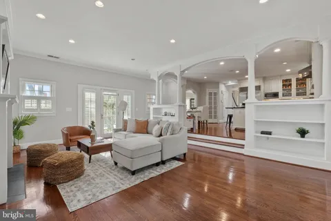 a kitchen with a sink stove cabinets and wooden floor