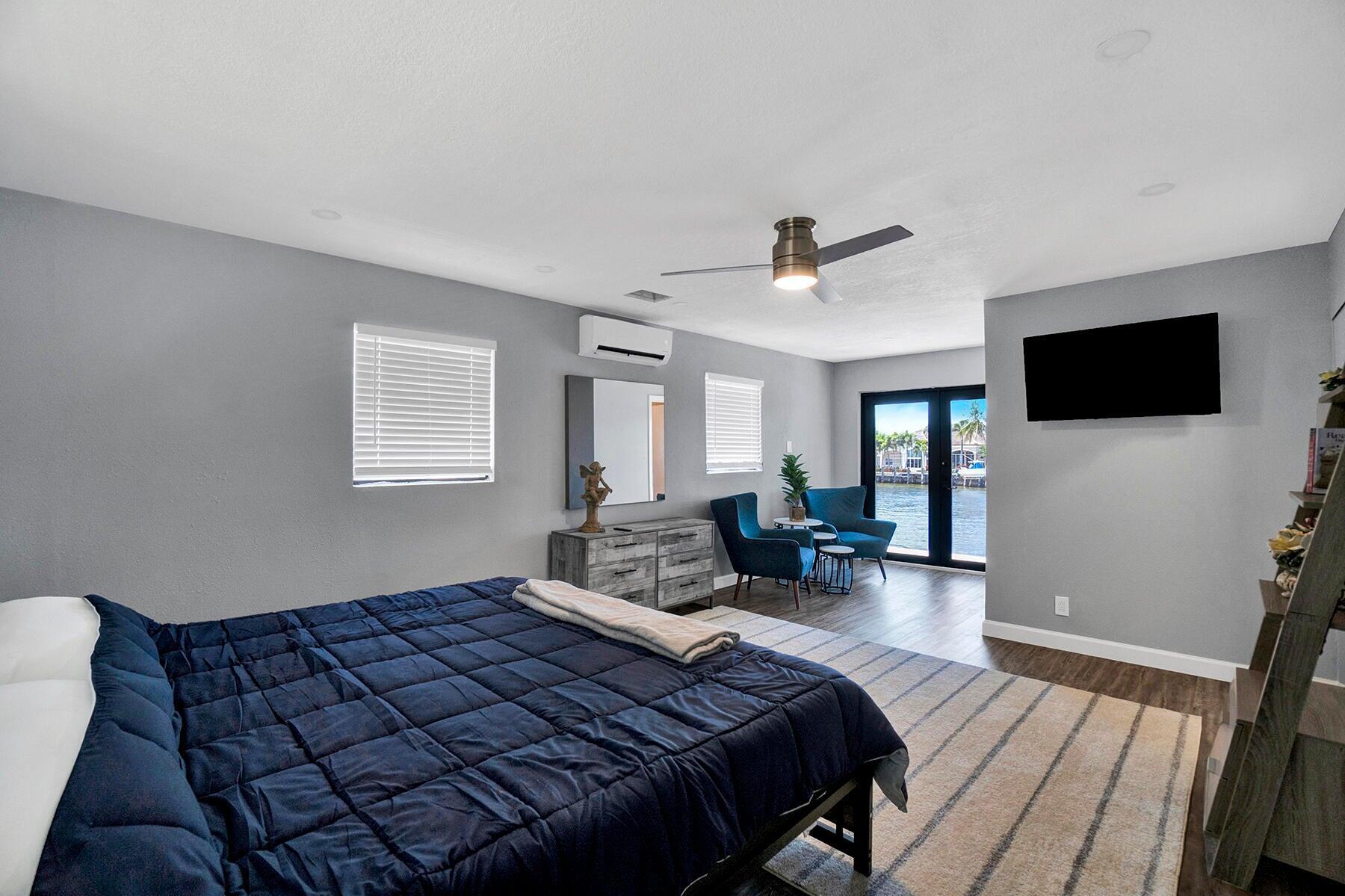 1901 North Riverside Drive, Unit 1 Pompano Beach, FL 33062 - Photo 14 of 26 a spacious bedroom with a bed and a flat screen tv