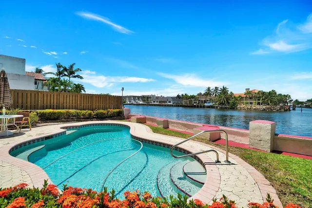 a view of a swimming pool with a lounge chair and a lake view