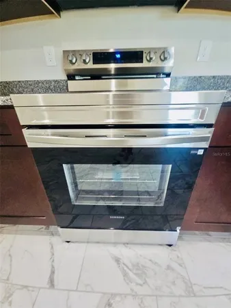 a kitchen with granite countertop cabinets stove and oven