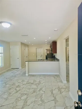 a view of kitchen with refrigerator and window