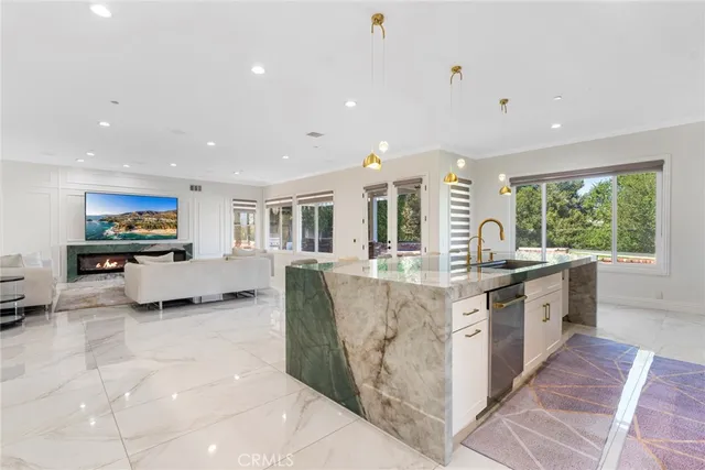 a kitchen with stainless steel appliances kitchen island granite countertop a stove a sink a dining table and chairs