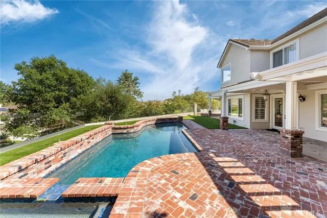 a aerial view of a house with swimming pool next to a yard