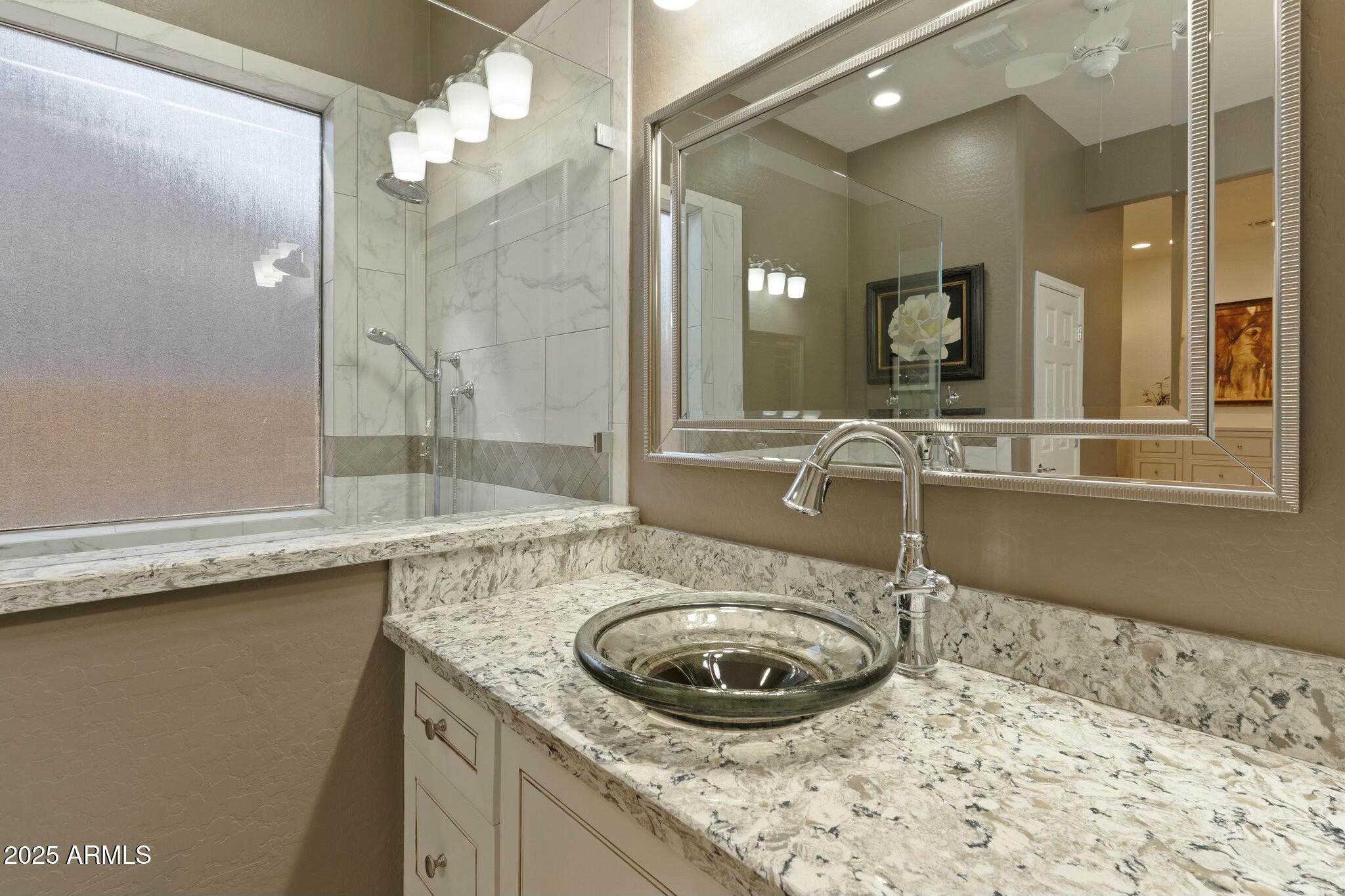 2022 West Steed Ridge Phoenix, AZ 85085 - Photo 23 of 85 a bathroom with a granite countertop sink a mirror and shower