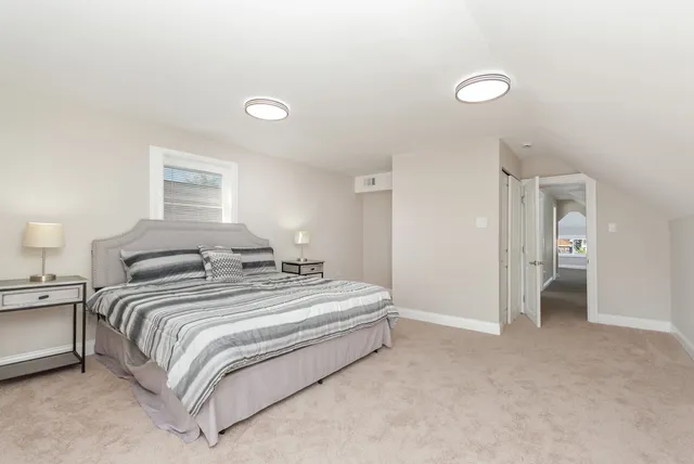 a spacious bedroom with a bed and a lamp