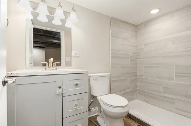 a bathroom with a sink a toilet and shower