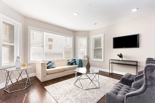 a living room with furniture and a flat screen tv next to a window