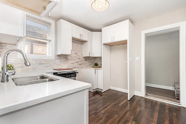 a kitchen with a sink cabinets stainless steel appliances and a window