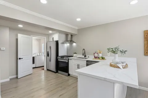 a kitchen with a refrigerator and a stove top oven