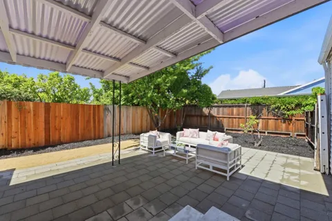 a view of a house with backyard and sitting area