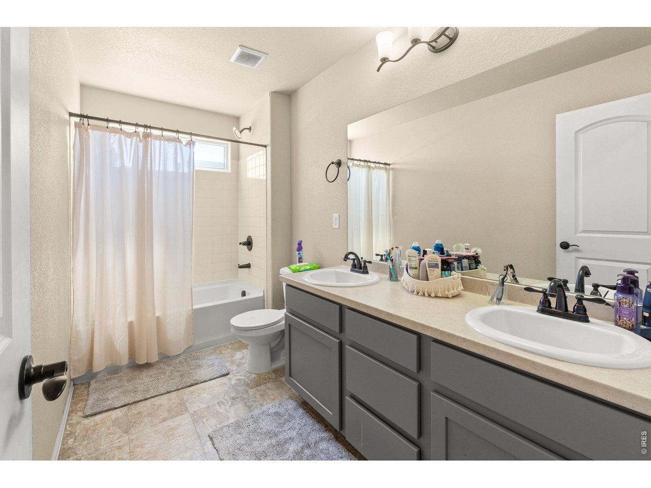 8847 16th St Road Greeley, CO 80634 - Photo 26 of 38 a bathroom with a double vanity sink toilet and a mirror